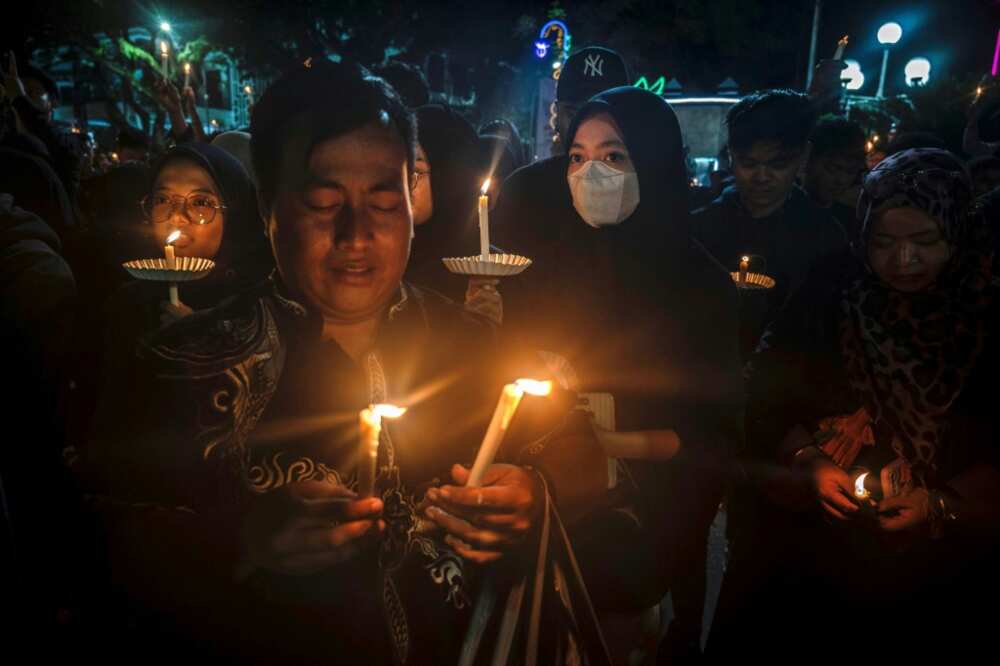 People light candles as they gather on Wednesday to pray in memory of the victims of a stampede