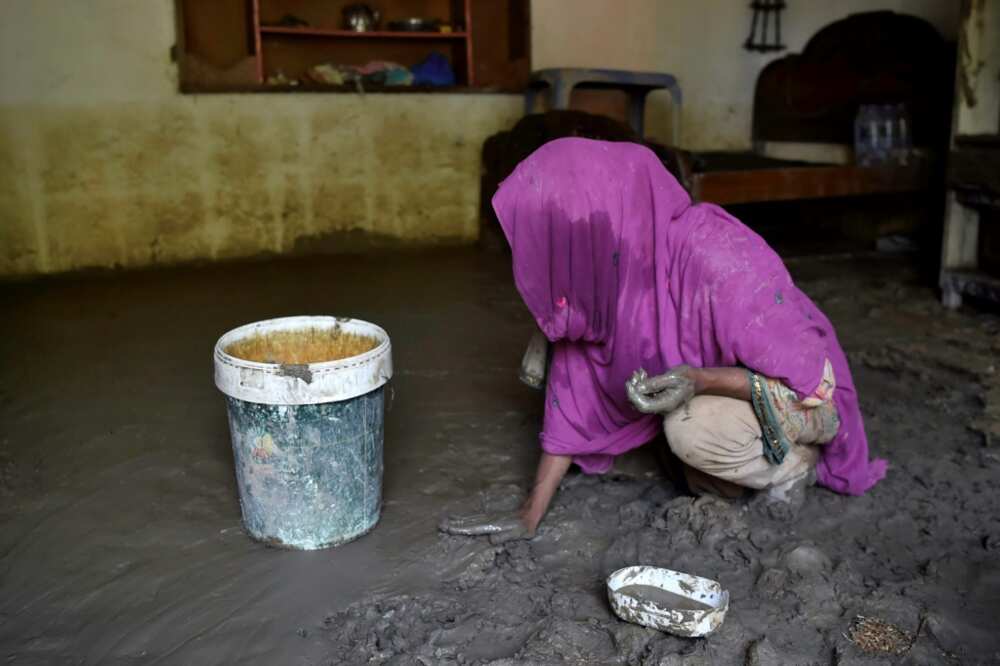 Hajira Bibi tackles her mud-filled home in Jindi village