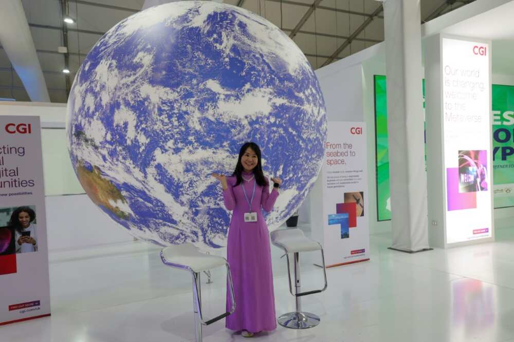 A delegate poses for a picture in an exhibitions pavilion at the convention center hosting the COP27 climate conference