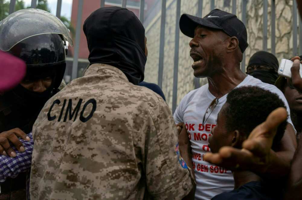 A man argues with a policeman outside the Canadian embassy during a protest in Port-au-Prince, Haiti, on October 24, 2022