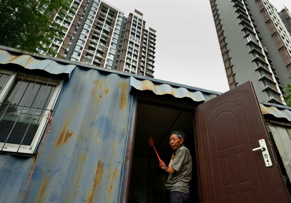 A migrant worker stands at the entrance to his living quarters in Beijing's middle-class neighbourhood of Shangdi