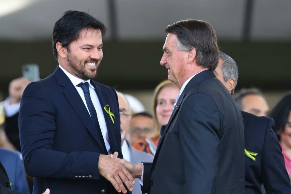 Brazilian President Jair Bolsonaro (R) is seen with his communications minister Fabio Faria in Brasilia on August 25, 2022