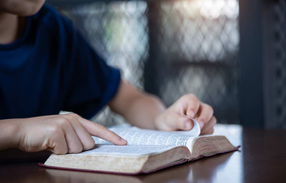A person reading the Bible while pointing to the text with their finger