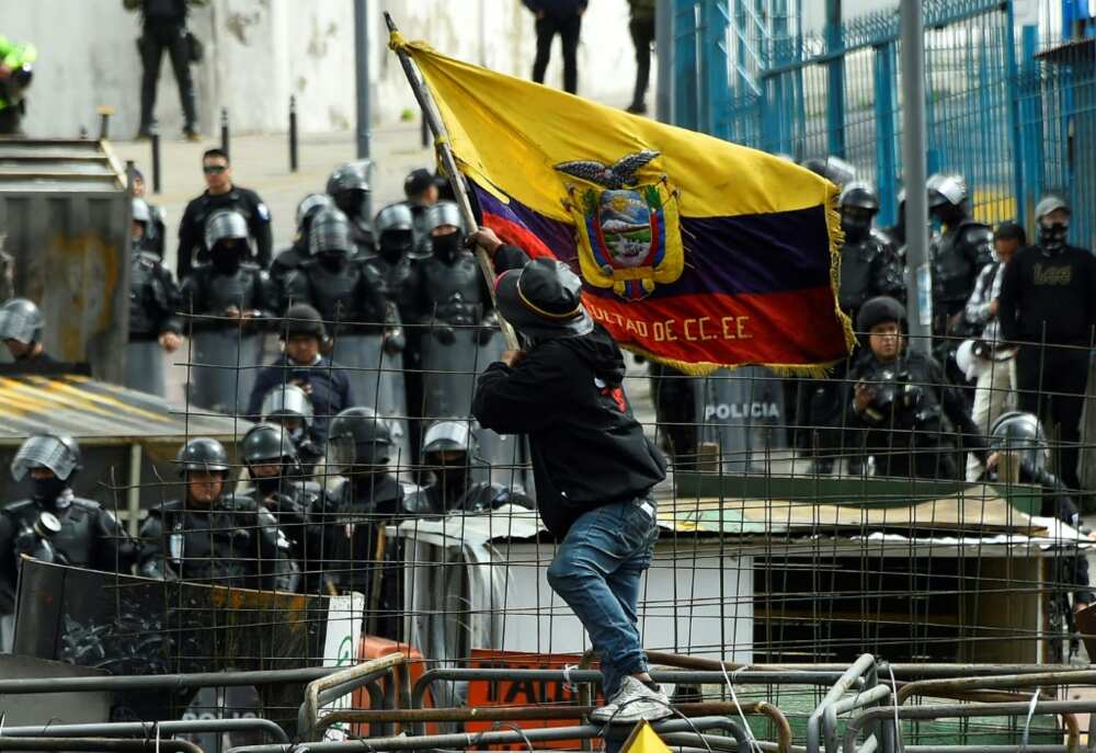 A demonstrator faces off with police officers near the National Assembly in Quito on June 25, 2022 A demonstrator faces off with police officers near the National Assembly in Quito on June 25, 2022