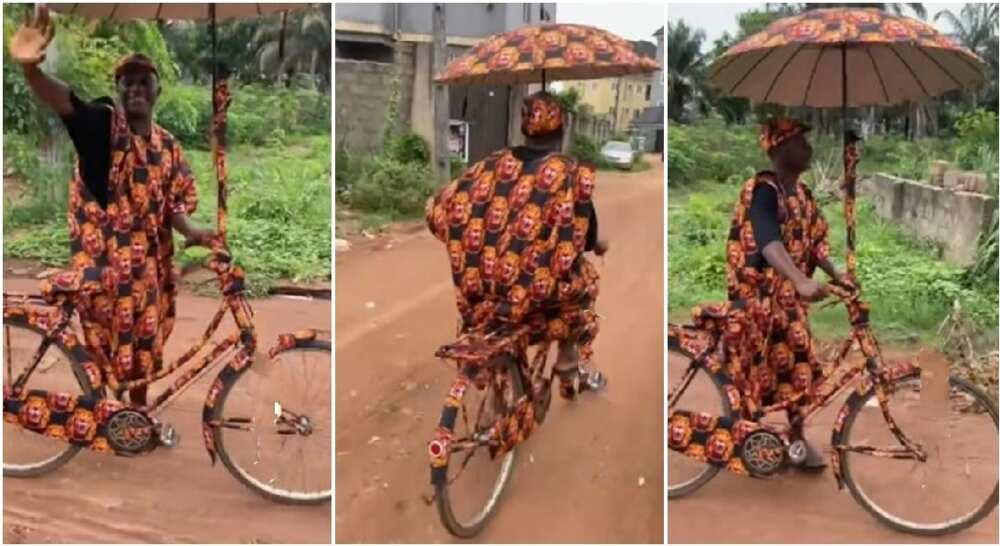 Nigerian man dresses himself, his bicycle and umbrella in Isiagu dress.