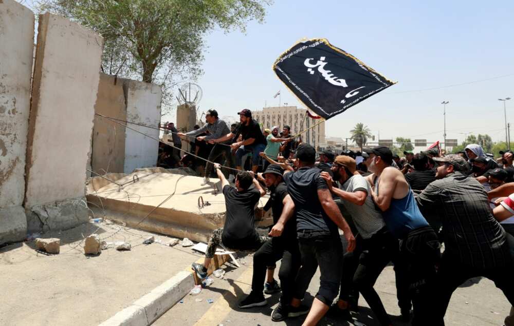 Sadr supporters tear down a concrete barrier before breaching the Green Zone Sadr supporters tear down a concrete barrier before breaching the Green Zone
