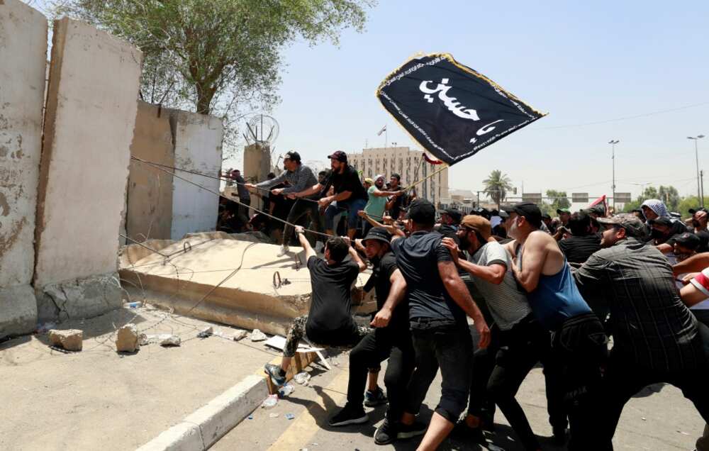 Sadr supporters tear down a concrete barrier before breaching the Green Zone