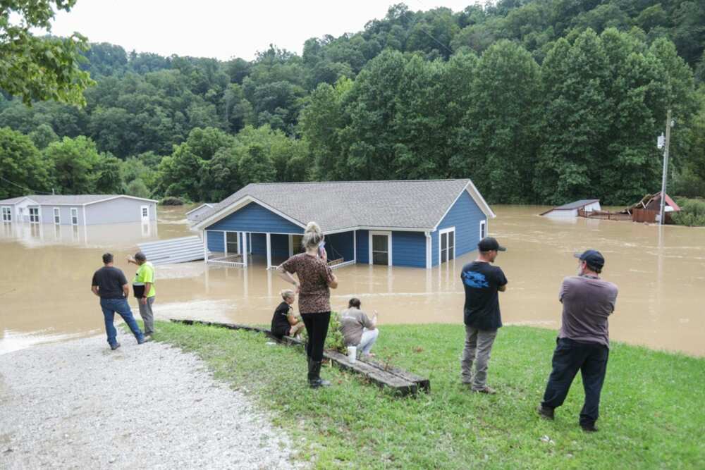 A family looks at their submerged home in Jackson, Kentucky