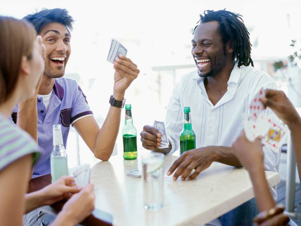 Four young people playing cards