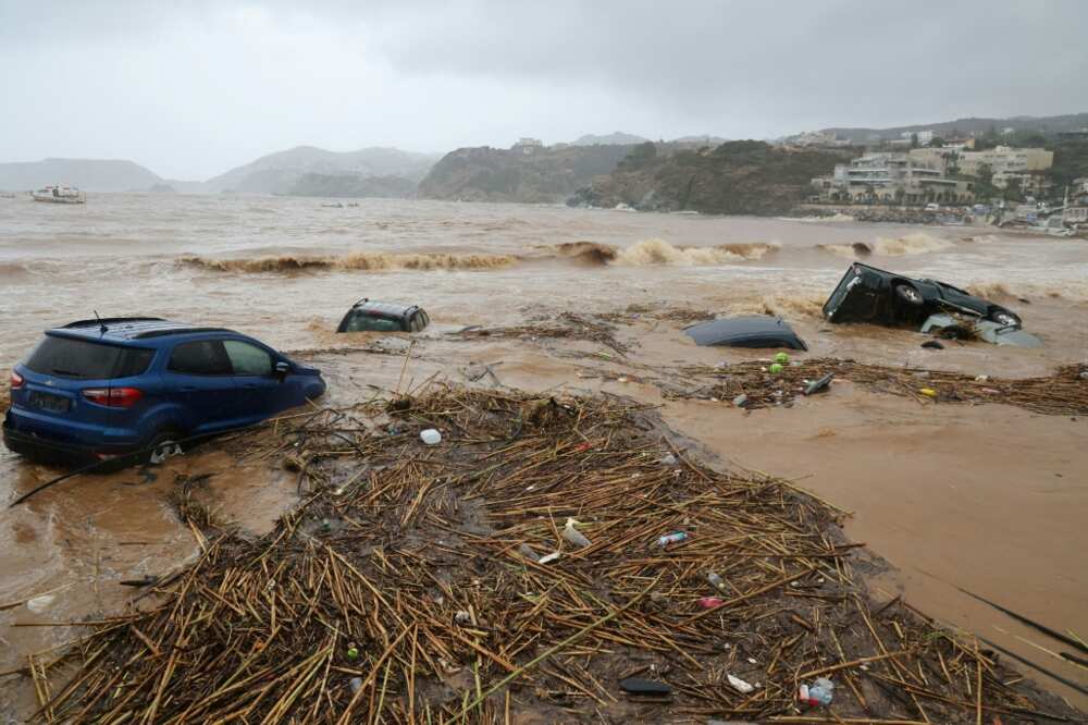 Cars are carried away by floods at the beach of the popular resort of Agia Pelagia, on the southern Greek island of Crete, following flash floods on October 15, 2022