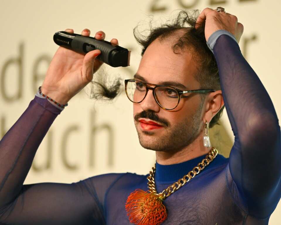The author took to the stage and sang a song, before using an electric razor to shave off their hair on the podium