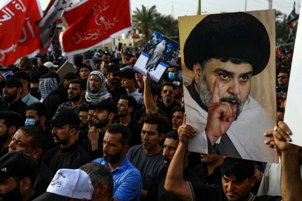 Supporters of Shiite cleric Moqtada Sadr carry portraits of him as they gather in the southern Iraqi city of Nasiriyah