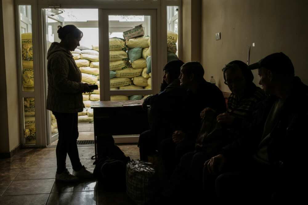People wait to be evacuated  in Kozacha Lopan, one of the first towns to fall in this month's dramatic Ukrainian advance