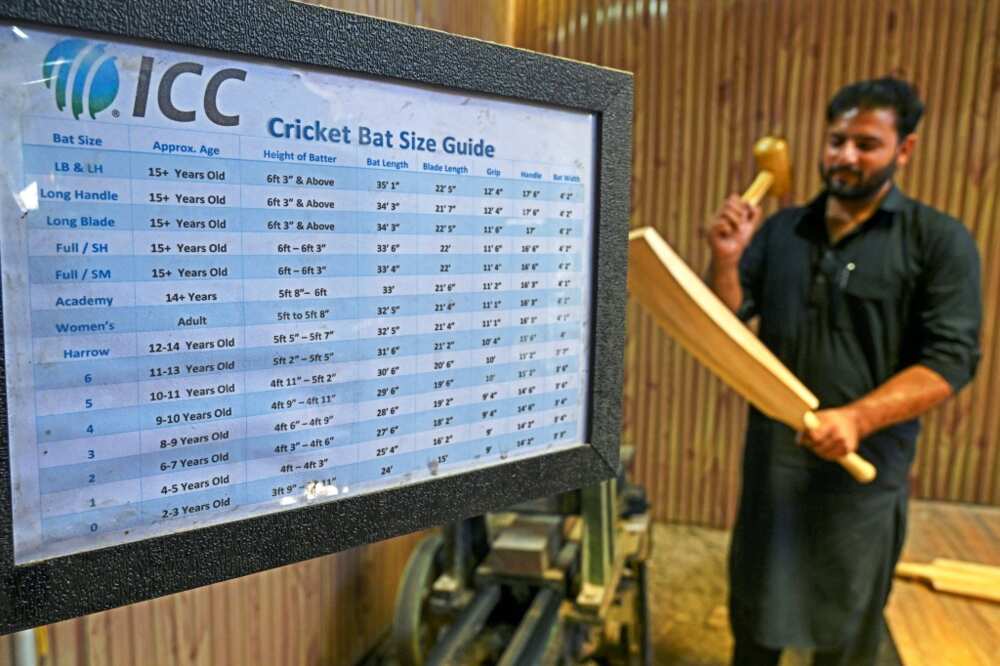 Owner of GR8 Sports Fawzul Kabiir inspects a Kashmiri willow cricket bat at his factory in Kashmir's Sangam village