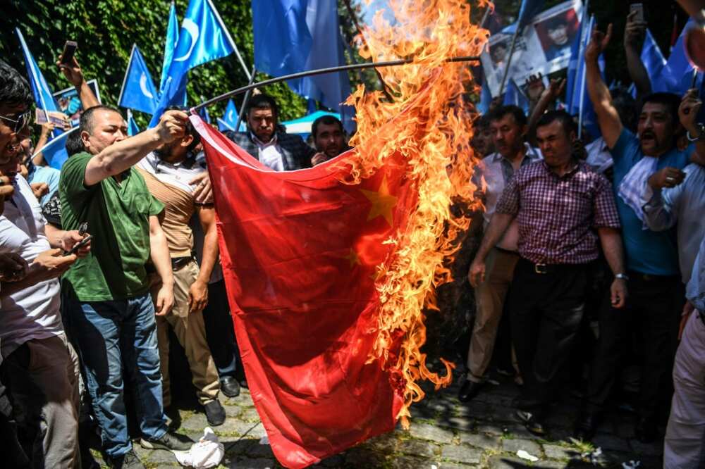 Supporters of the mostly Muslim Uyghur minority and Turkish nationalists burn a Chinese flag during a protest