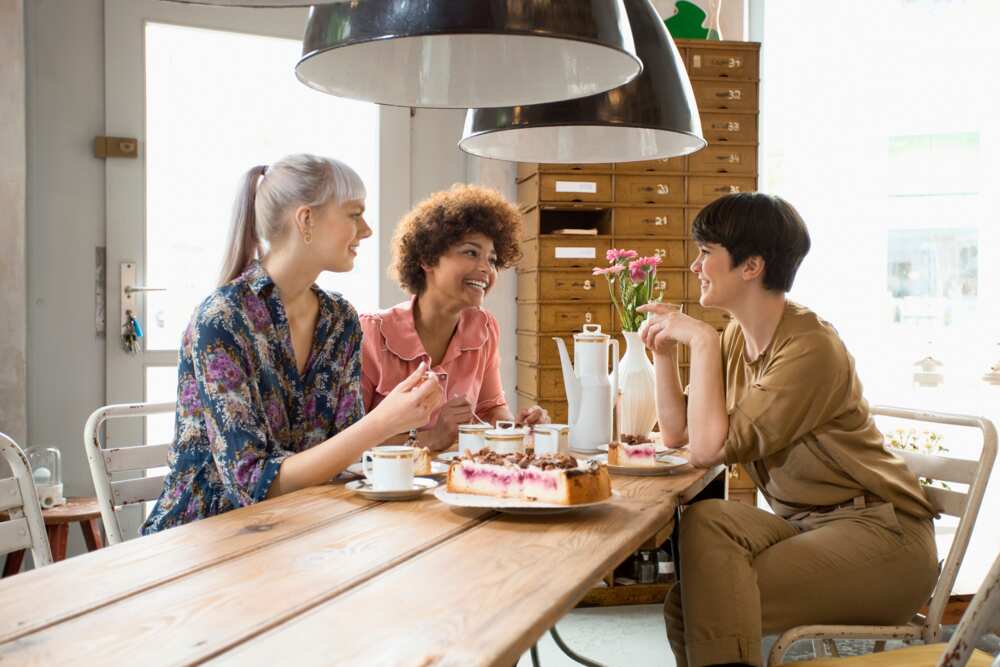 Three ladies sits enjoying a meal