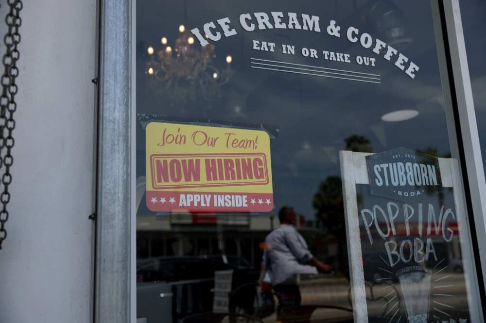 A 'Now Hiring' sign posted outside of a restaurant in Miami, Florida A 'Now Hiring' sign posted outside of a restaurant in Miami, Florida