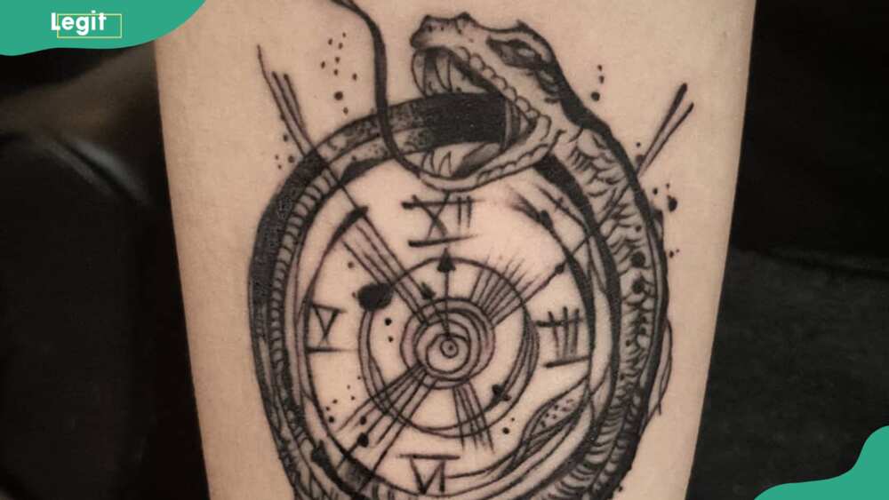 Serpent wrapped around a clock tattoo
