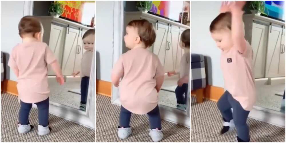 Baby gets tired of boredom, looks into the mirror and dances effortlessly