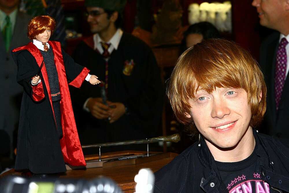 Actor Rupert Grint stands beside a doll depicting his character Ron Weasley