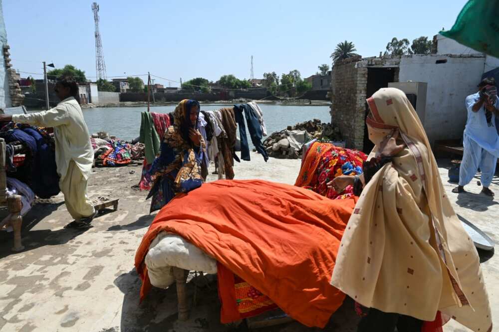Mureed Hussain and other family members lay their belongings out in the sun to dry after their home was inundated with flood water