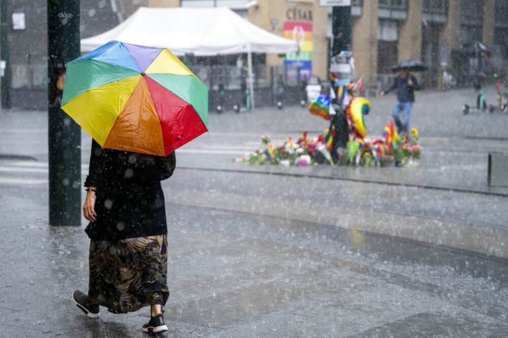 A woman walks past the memorial at the site in Oslo, Norway where two people where shot in an attack against several gay bars