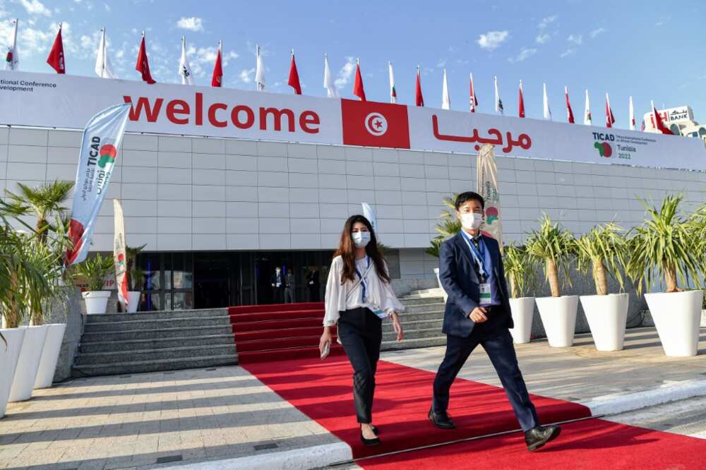 Attendees walk outside the Congress Palace, hosting the eighth Tokyo International Conference on African Development (TICAD8), ahead of its opening in Tunisia's capital Tunis on August 27, 2022