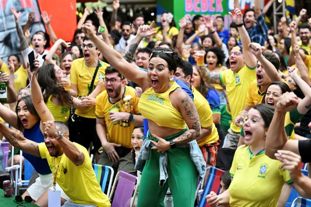 Fans of Brazil react while watching the broadcast of the Qatar 2022 World Cup Group G football match between Brazil and Serbia at a bar in Brasilia, on November 24, 2022