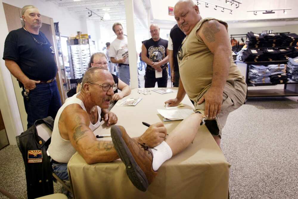 Barger autographs the artificial leg of Kenny Little during an event at a Harley-Davidson motorcycle dealership in 2003