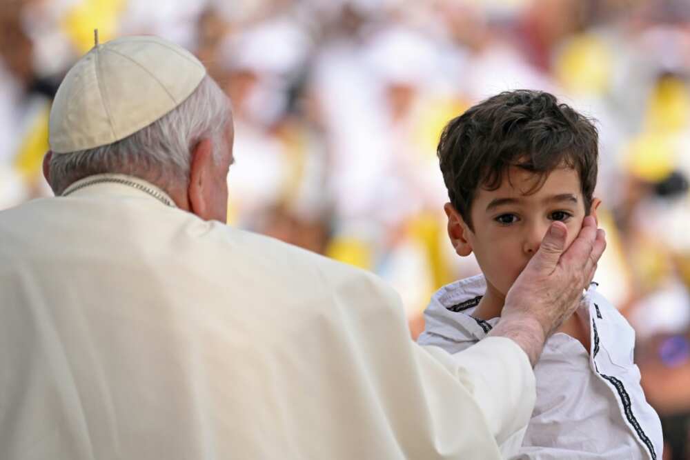 Francis blesses a child at the stadium