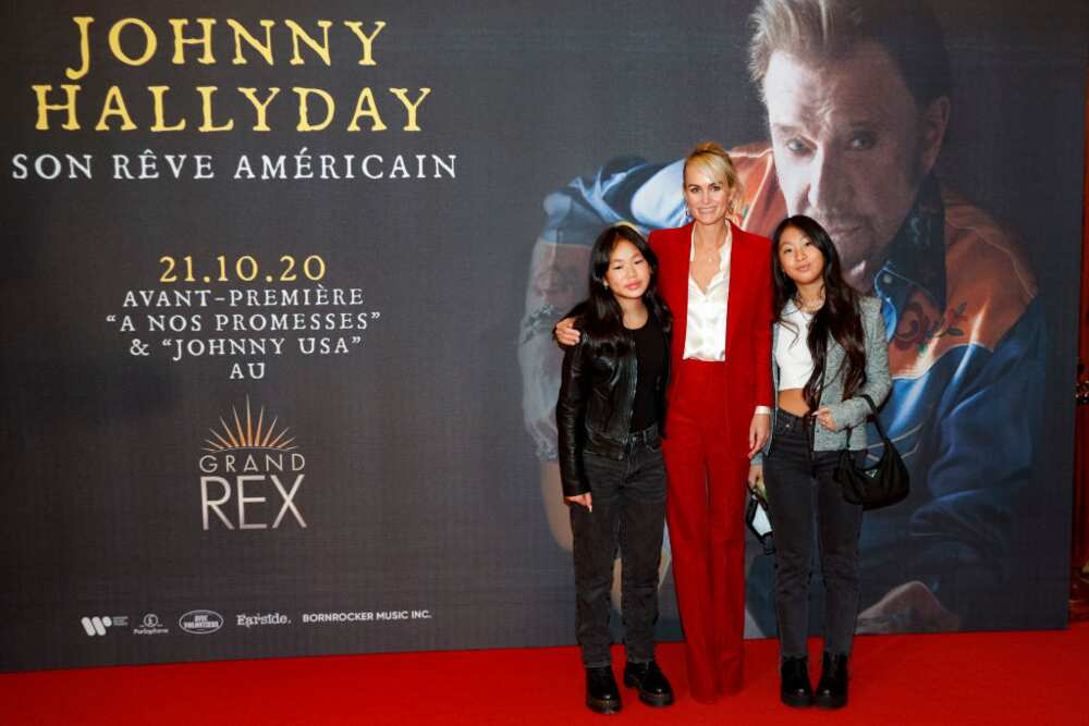 Laeticia Hallyday pose avec leurs filles à leur arrivée à l'avant-première du film "Johnny Hallyday, son rêve américain" au cinéma Grand Rex à Paris le 21 octobre 2020. (Photo GEOFFROY VAN DER HASSELT/AFP)