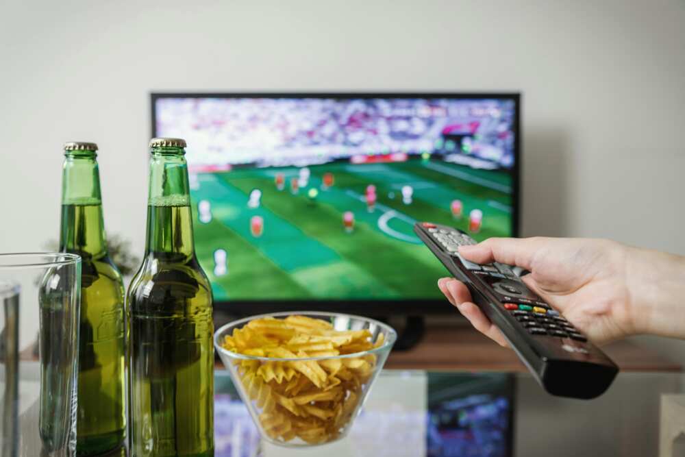 a person watching a football match on TV