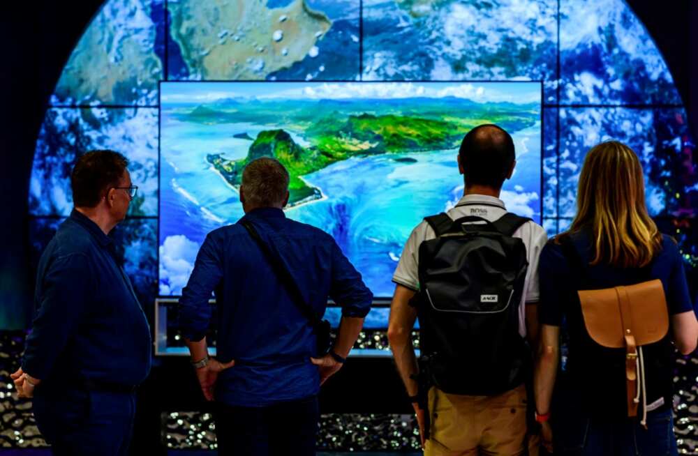 Visitors contemplate an 8K TV at the stand of South Korean consumer goods giant LG at the tech fair -- motto this year "energy efficiency"