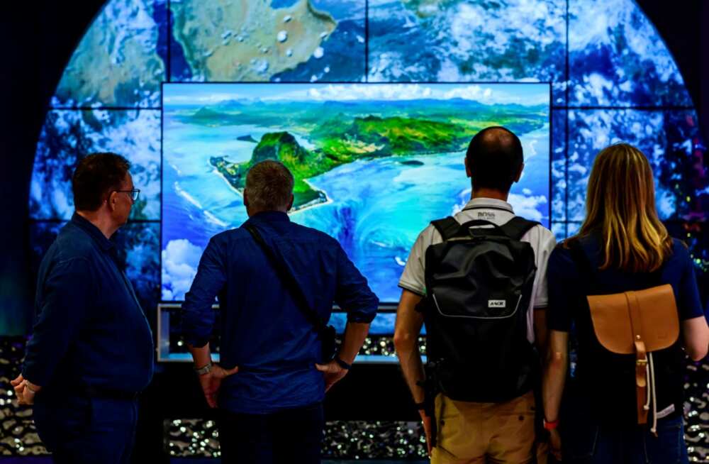 Visitors contemplate an 8K TV at the stand of South Korean consumer goods giant LG at the tech fair -- motto this year "energy efficiency" Visitors contemplate an 8K TV at the stand of South Korean consumer goods giant LG at the tech fair -- motto this year "energy efficiency"