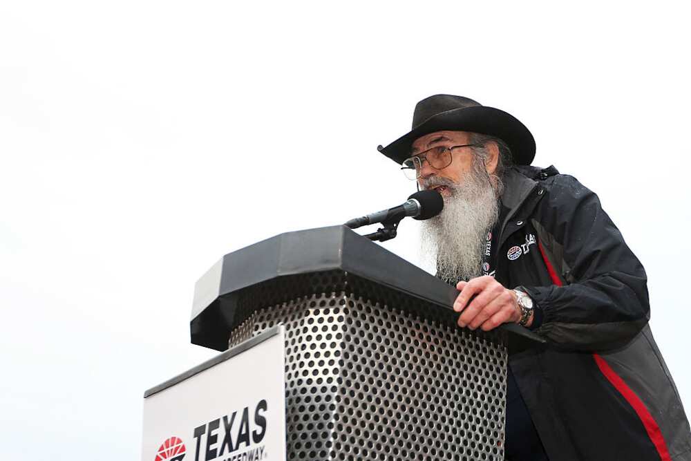 Si Robertson of Duck Dynasty in a black and red coat speaking onstage