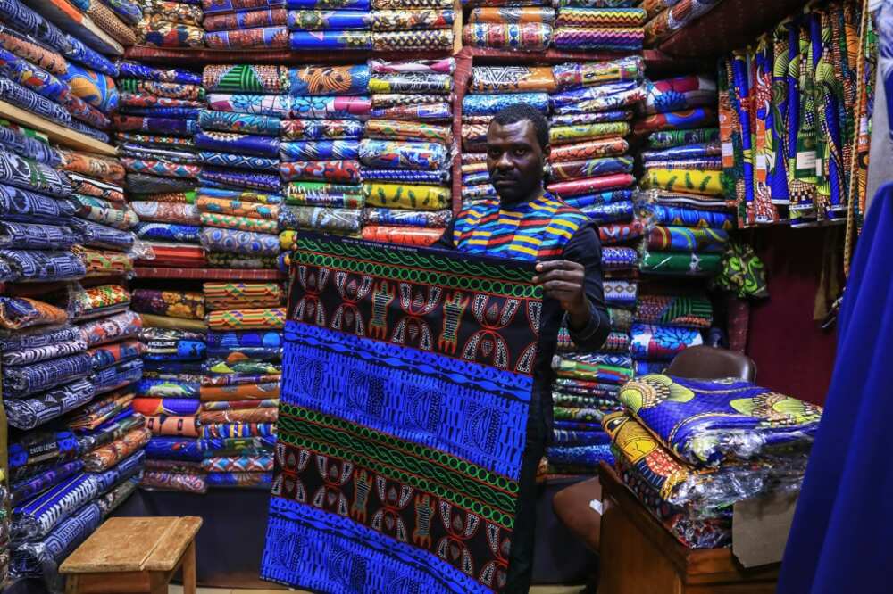 Iridescent: A trader holds a piece of the bright blue ndop ceremonial cloth in Bafoussam market in Cameroon