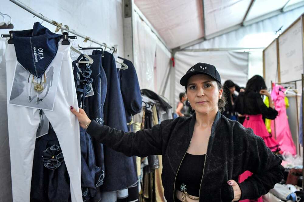 French fashion designer Maud Beneteau poses for a photograph with her designs backstage during a fashion show at Tunisia's Carthage Museum for the launch of Outa French fashion designer Maud Beneteau poses for a photograph with her designs backstage during a fashion show at Tunisia's Carthage Museum for the launch of Outa