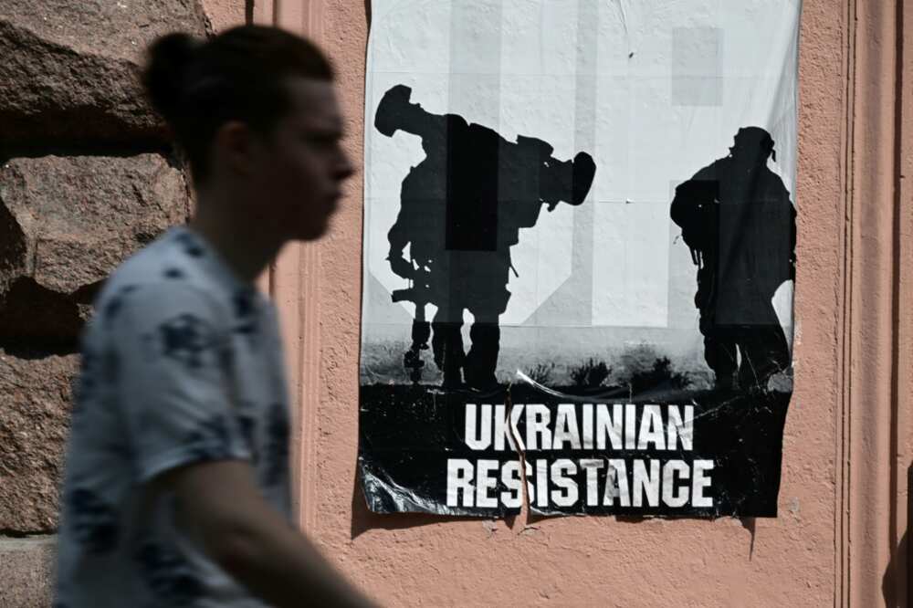 A man passes by a poster reading "Ukrainian Resistance" in central Kyiv, on June 30, 2022 amid the Russian invasion of Ukraine