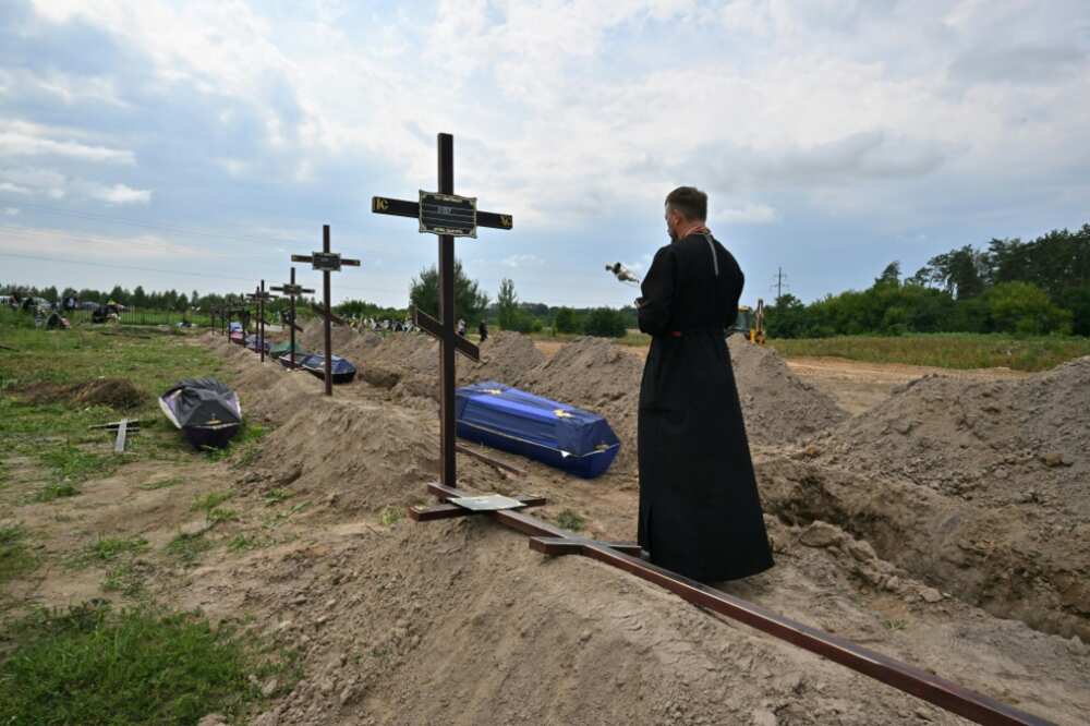 An Orthodox priest prays at a funeral in the town of Bucha near Kyiv, the site of alleged attrocities by Russia