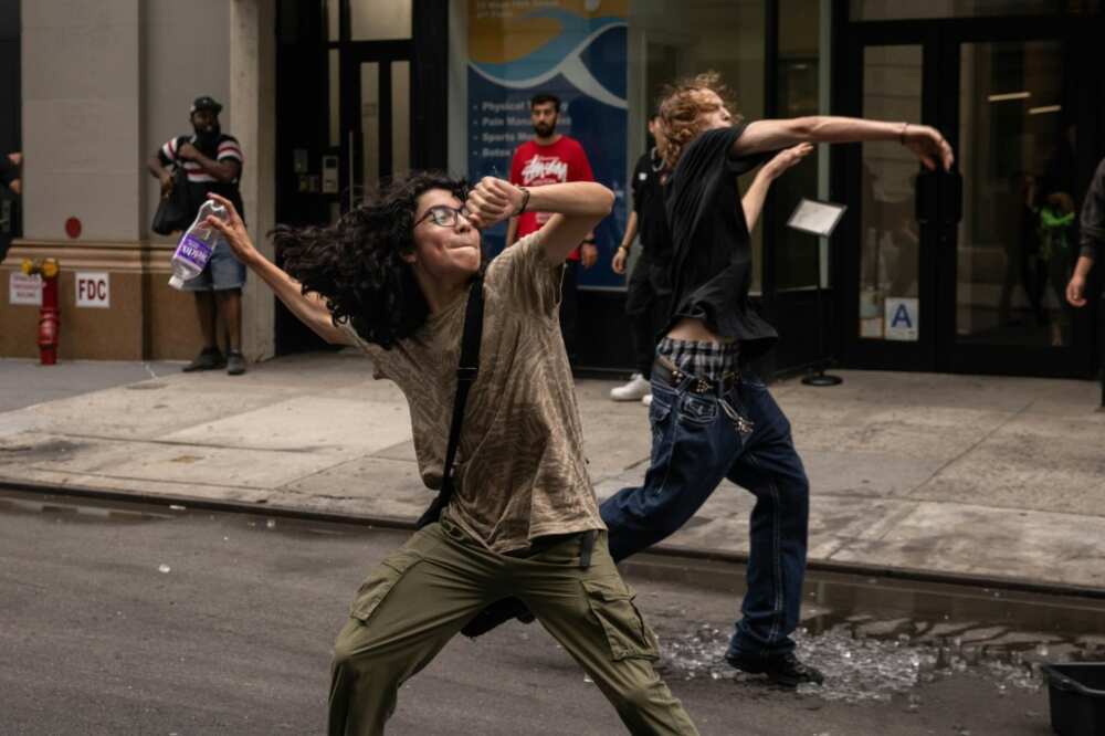 People throw ceramic plates and water bottles at police officers during riots sparked by Twitch streamer Kai Cenat, who announced a "giveaway" event in New York's Union Square on August 4, 2023