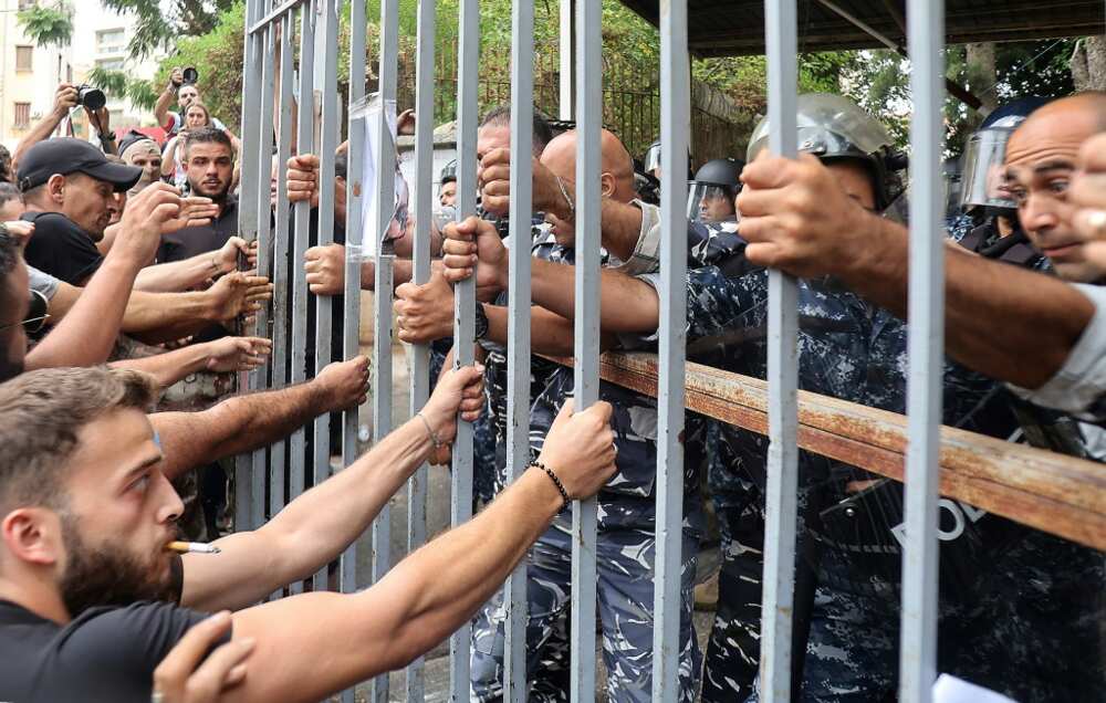 Protesters at the gates of the Justice Palace in Lebanon's capital Beirut on September 19, 202, demand the release of two people involved in a bank hold-up last week