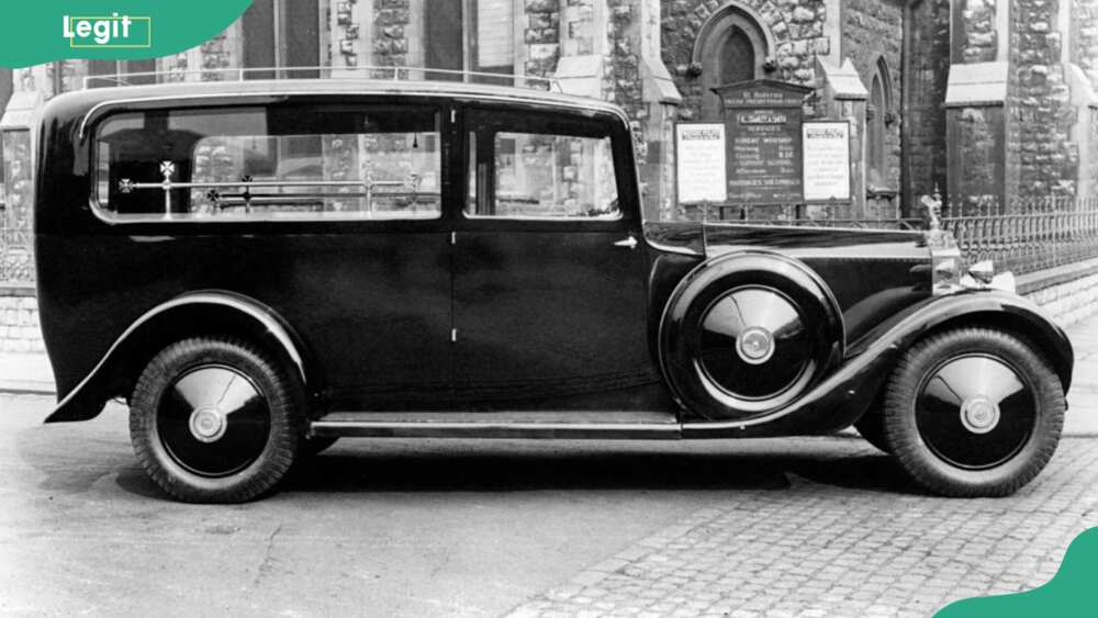 1929 Rolls Royce Phantom 1 hearse outside a large building
