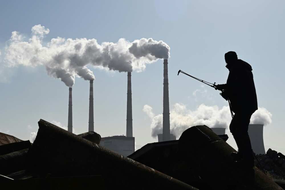 A worker using a torch to cut steel pipes near the coal-powered Datang International Zhangjiakou Power Station in China's northern Hebei province in November 2021