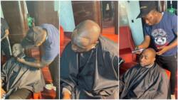 Photos & videos show man giving Davido haircut for his birthday, Nigerians comment about barber's skill