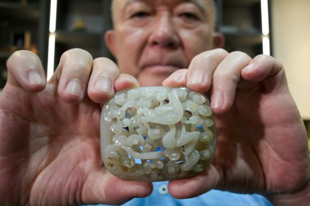 Chang Juben, chairman of Taiwan's Association of Jade Collectors, shows a Yuan dynasty jade belt ornament featuring a carving of a dragon among clouds