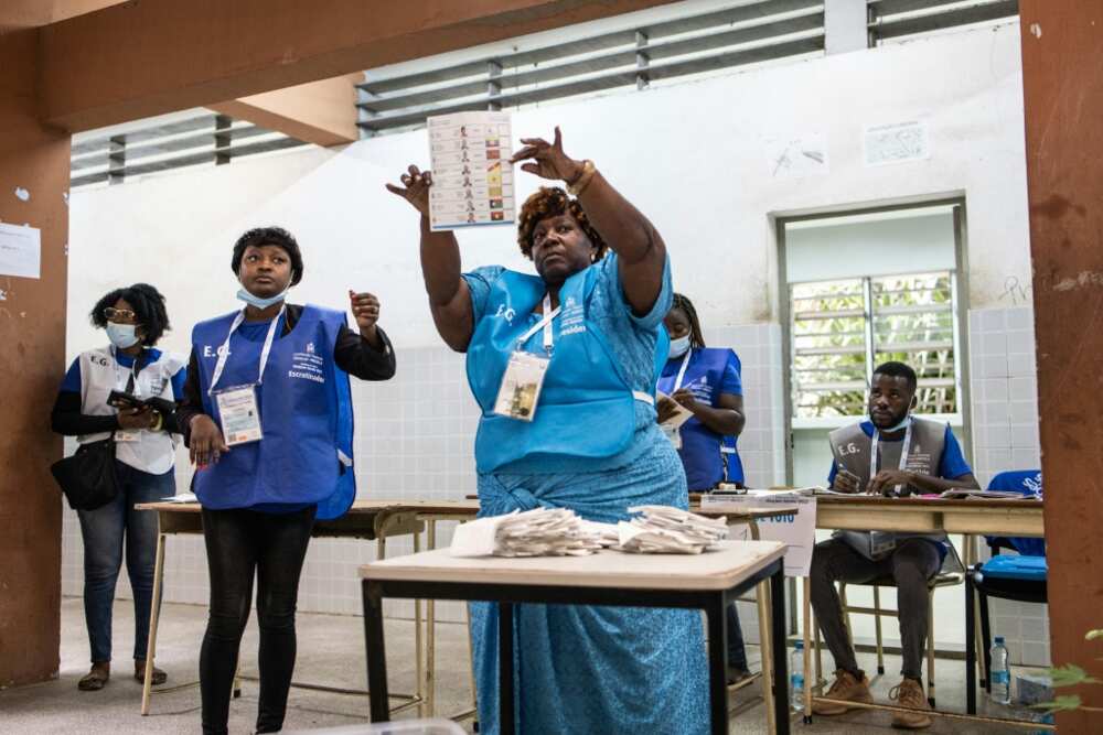 An election official holds up a ballot paper as votes are counted at a polling station in Luanda on August 24, 2022, during Angola's general elections