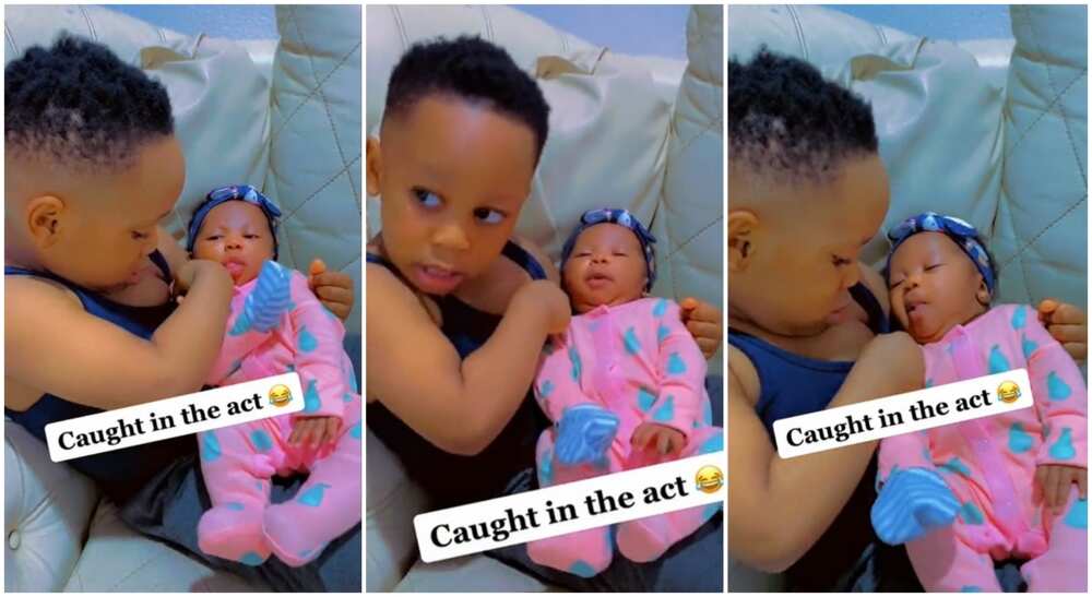 Photos of a Nigerian boy cuddling his baby sister and trying hard to breastfeed her.