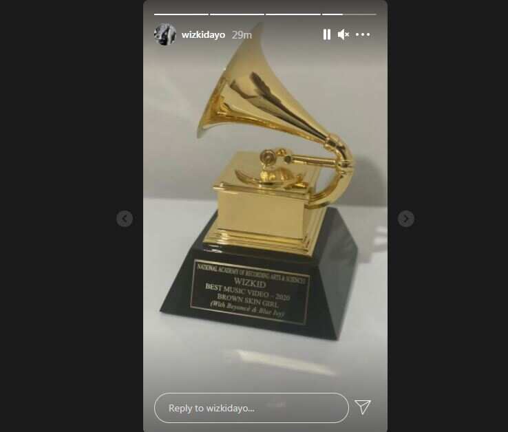 Wizkid receives his Grammy award plaque.