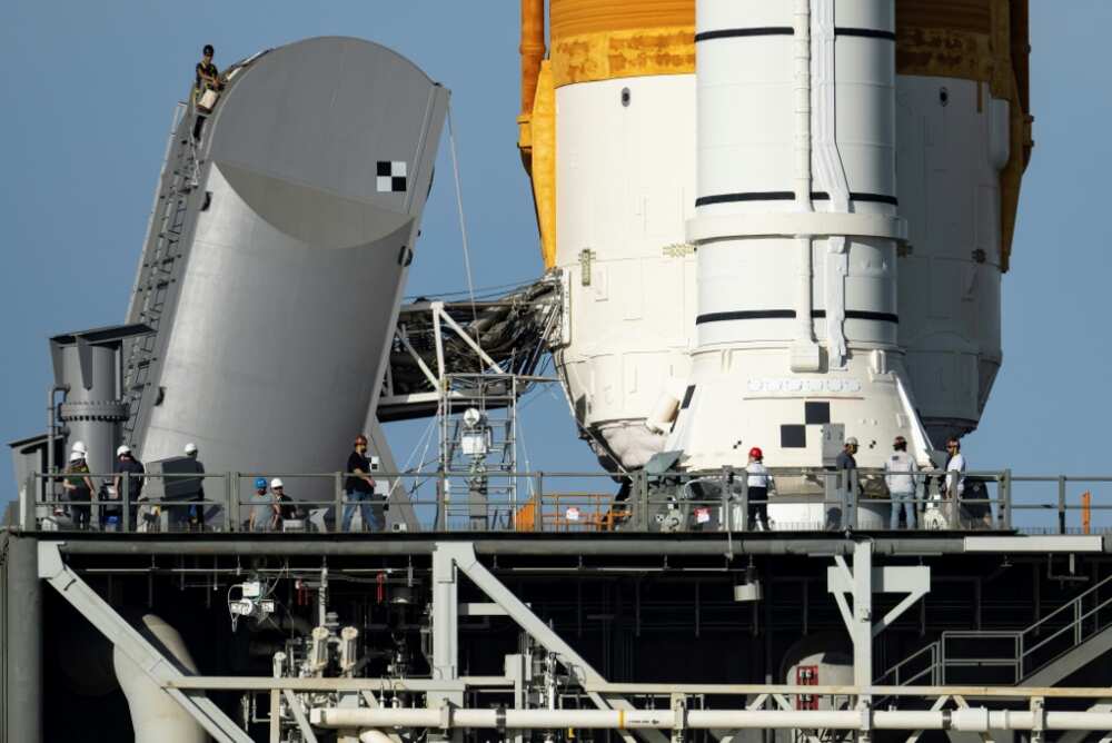 Engineers work on the Tail Service Mast Umbilical of the Artemis I unmanned lunar rocket as it sits on launch pad 39B at NASA's Kennedy Space Center