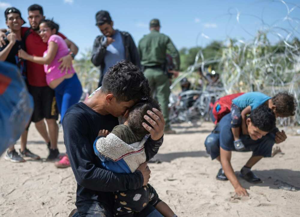 A migrant family from Venezuela breaks through a razor wire barricade into the United States on the Rio Grande river in Eagle Pass, Texas, on September 25, 2023